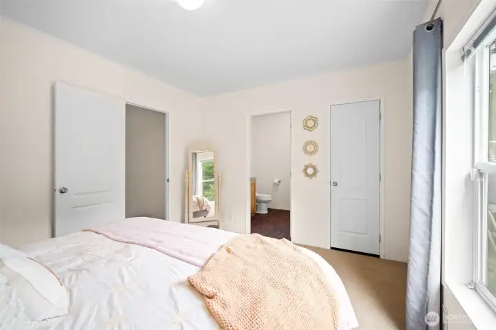 Bright, simple, clean primary bedroom with ensuite bath.