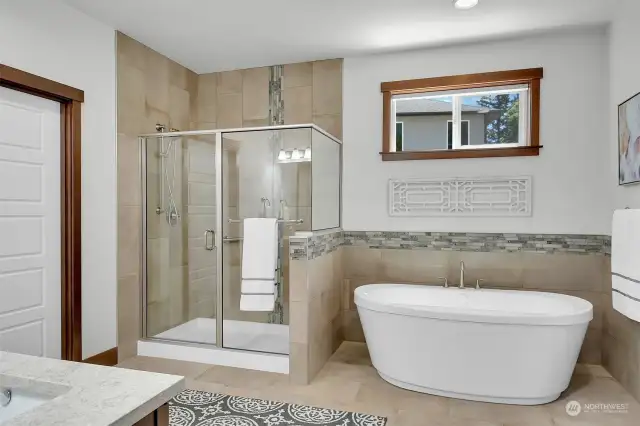 Beautiful tiled primary suite bathroom with shower & soaking tub.