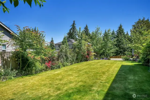 Meticulously maintained yard and gardens with a variety of colorful plantings, fruit trees and berries.
