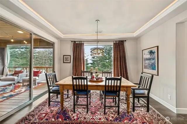 Sun filled dining room with covered deck to the left. Stairs to basement are just off to the right.