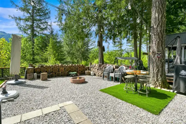 Fantastic fire pit area. Beautiful, landscaped lot with premium artificial grass and quality lighting.