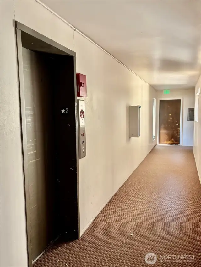 Across from the storage closet is the elevator to the lower level parking area. The door at the far end is the laundry room for this level. HOA allows laundry connections to be added into the apartment, if one wanted to do so.
