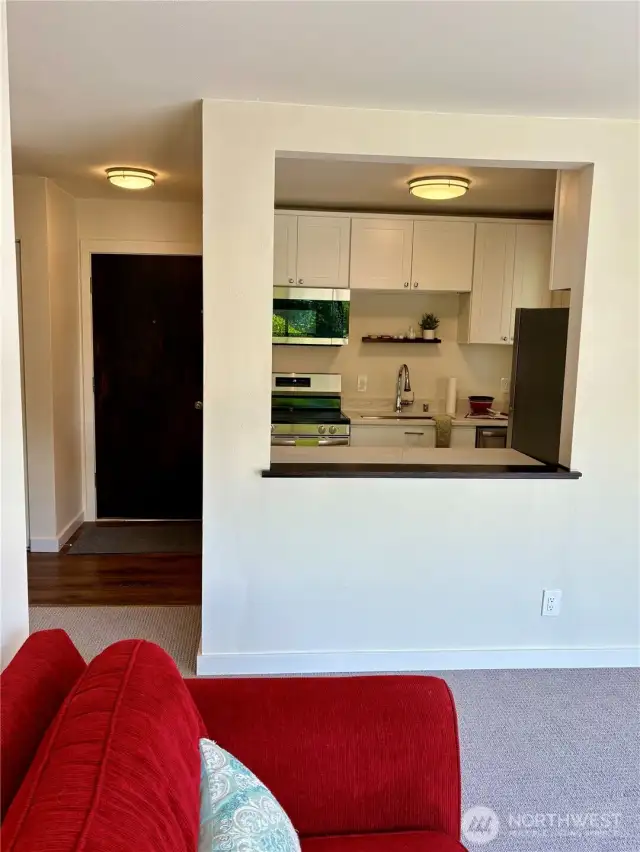 The large living area is open to the kitchen; with the entry door at the left.