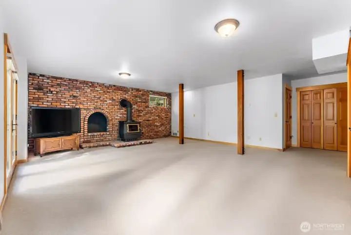 Bonus room in walkout daylight basement. Well lighted. Closet. Utility room and storage. Wood fireplace is freestanding. Real vintage brick. Electric heat.