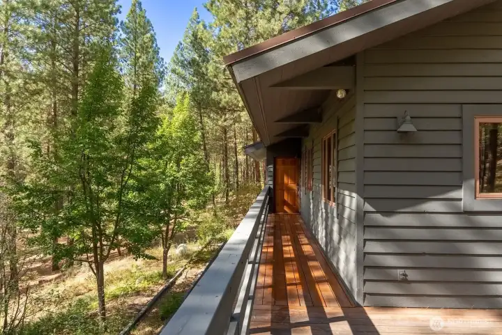 Covered wood deck walkway on main level of the home.