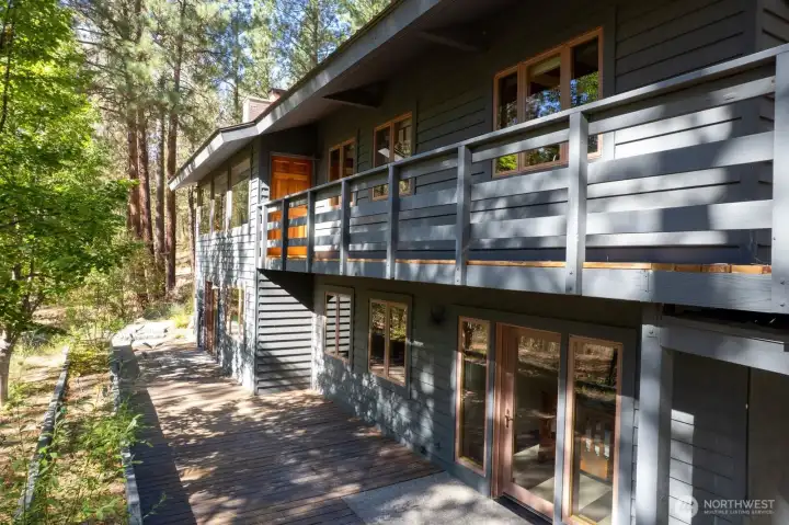 South side of this home has main level wood deck walkway and Daylight basement wood terrace area.