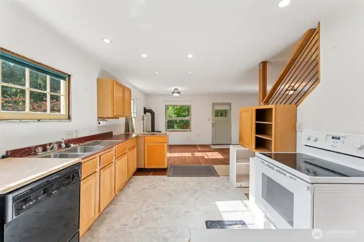 Kitchen to Dining space and cozy propane free standing stove.  (Dishwasher is portable)
