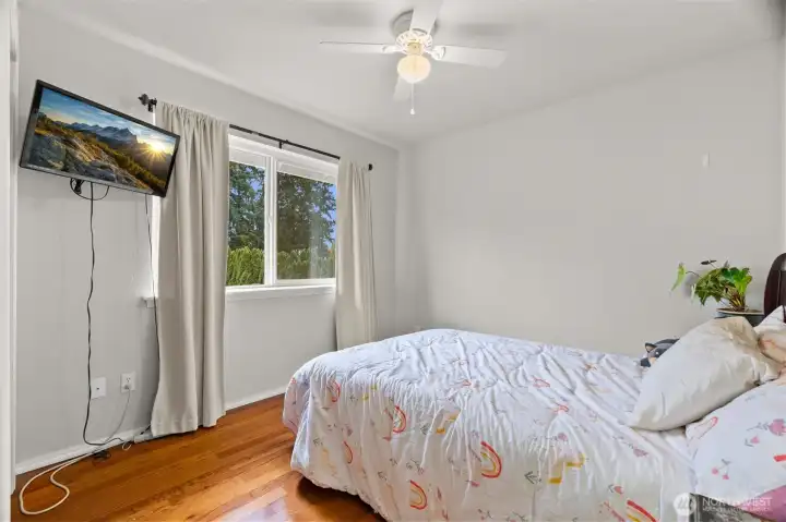Second bedroom upstairs with ceiling fan and hardwood floors.