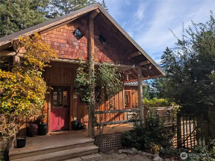 A covered front porch with climbing hydrangea and red rose will welcome you home.