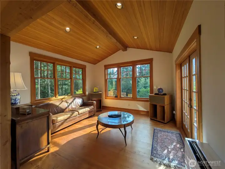 This great room is warm and welcoming with fir floors, windows and ceiling.