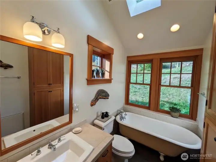 Primary bathroom with luxurious clawfoot tub for long soaking baths all year round. Cool in the summer with windows for a breeze.