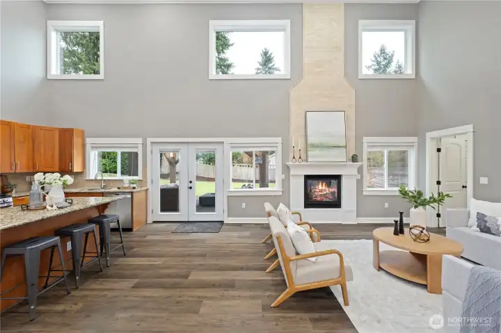 Gorgeous natural light from the expansive windows and 2-story ceilings overlooking the level, south-facing backyard.