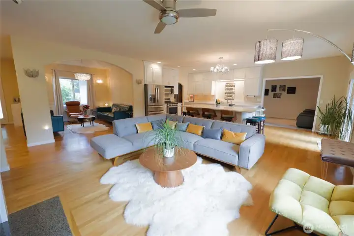 A bright, expansive living area offers comfortable seating, a ceiling fan, and direct sightlines to the kitchen and deck beyond. A bright, expansive living area offers comfortable seating, a ceiling fan, and direct sightlines to the kitchen and deck beyond.