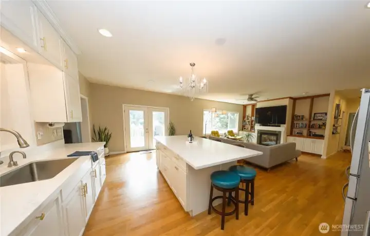 A spacious island with bar seating and French doors leading onto the deck, makes this kitchen a natural gathering spot, whether for casual meals or entertaining guests. A spacious island with bar seating and French doors leading onto the deck, makes this kitchen a natural gathering spot, whether for casual meals or entertaining guests.
