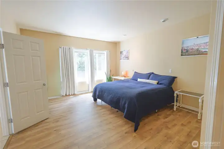The main-level primary suite offers convenience and privacy, with plenty of natural light, a double-door entry, large walk-in closet, and direct access to a private ensuite bath. The main-level primary suite offers convenience and privacy, with plenty of natural light, a double-door entry, large walk-in closet, and direct access to a private ensuite bath.