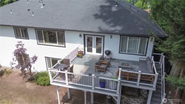 The expansive back deck is set for entertaining, with a cozy seating area, a fire table, and plenty of room to gather while taking in the water views. Partially virtually staged. The expansive back deck is set for entertaining, with a cozy seating area, a fire table, and plenty of room to gather while taking in the water views. Partially virtually staged.