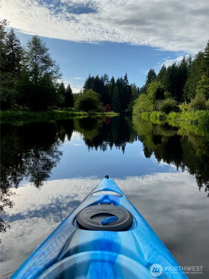 A kayak glides across the glassy surface of Lake Debra Jane, surrounded by reflections of evergreens and open sky, a perfect snapshot of everyday life on this lake. A kayak glides across the glassy surface of Lake Debra Jane, surrounded by reflections of evergreens and open sky, a perfect snapshot of everyday life on this lake.