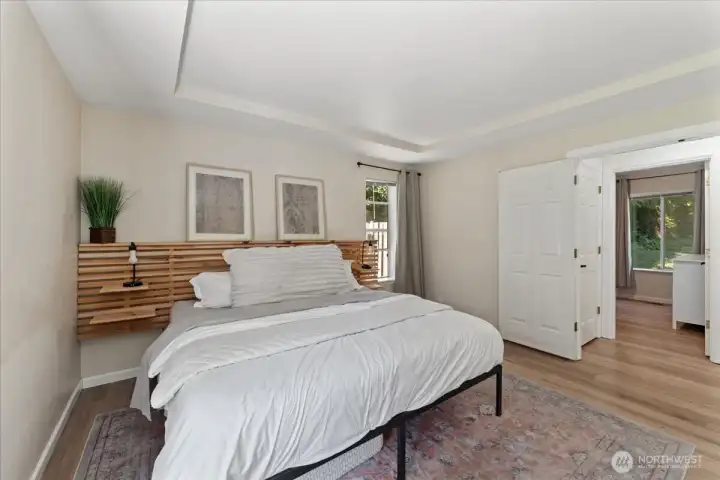 Primary bedroom is inviting and offers beautiful French doors, new LVP flooring, and fresh white painted millwork, coved ceiling creating a peaceful and luxurious retreat. Primary bedroom is inviting and offers beautiful French doors, new LVP flooring, and fresh white painted millwork, coved ceiling creating a peaceful and luxurious retreat.