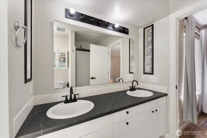 Functional and well-designed, the primary bath offers dual vanities, updated faucets, a jacuzzi soaking tub and walk-in shower. Functional and well-designed, the primary bath offers dual vanities, updated faucets, a jacuzzi soaking tub and walk-in shower.
