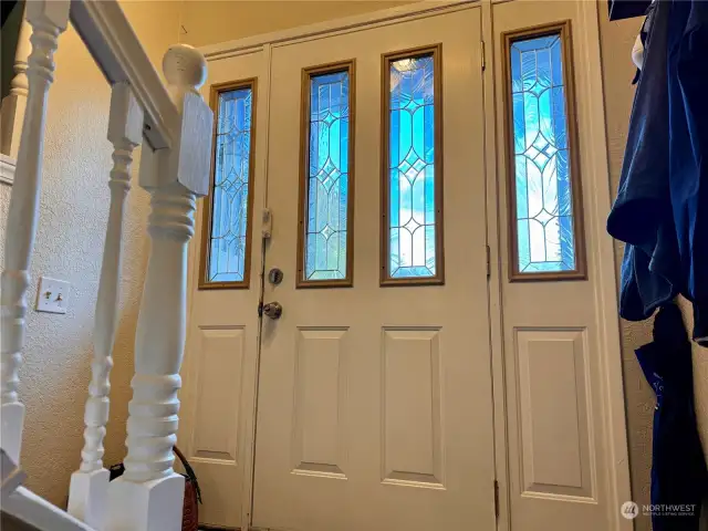 Beveled glass front door with side lights.