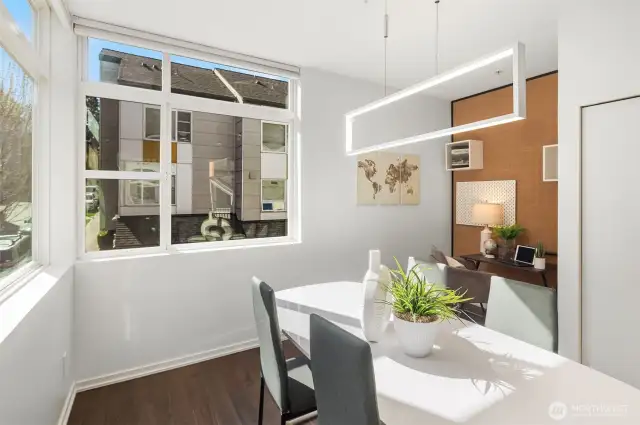 Spacious, sunny dining room features motorized blinds. The room is llarge enough for a work space.