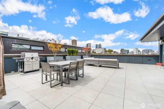 The well-appointed rooftop deck includes a seating area with fire feature, dining table, BBQ and views!