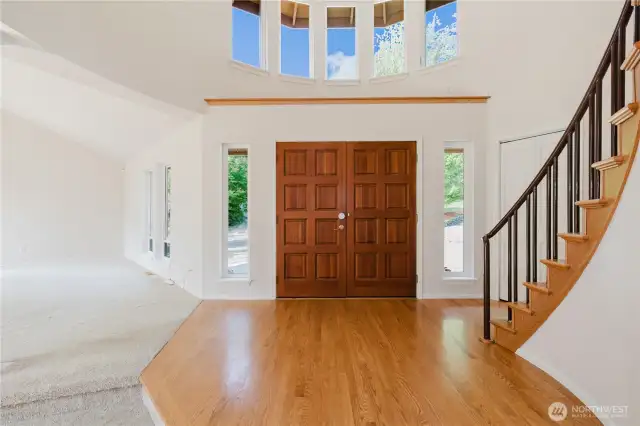 The elegant rotunda foyer captivates with its soaring ceiling and intricate details. Sunlight streams through large windows, A sweeping staircase leads to the second floor, where a luxurious primary bedroom awaits.