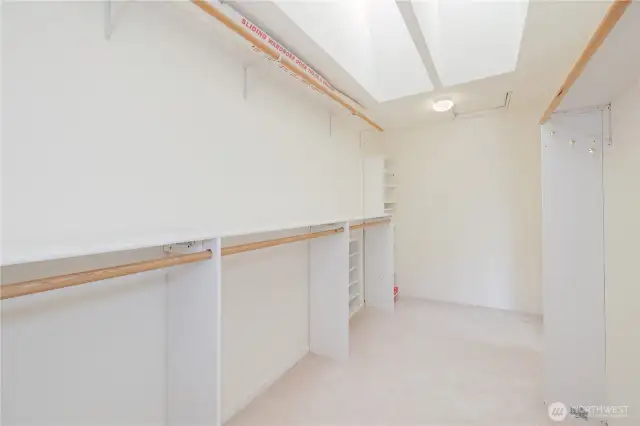 Primary walk-in closet with skylights.