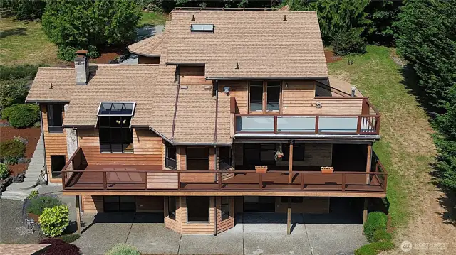 Multi-tiered outdoor oasis designed for relaxation and serenity. The upper primary personal deck offers an elevated space, Below, the main level decking expands the outdoor living space with enough room for a dining setup or lounge chairs, creating an ideal spot for entertaining guests or savoring a quiet meal. At ground level, the concrete patio provides a versatile area, making this outdoor area a sanctuary of peace after a hectic day.