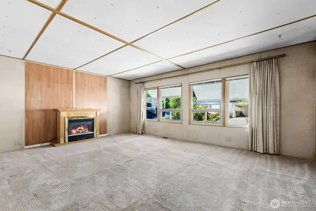 Generously sized living room with a cozy electric fireplace.