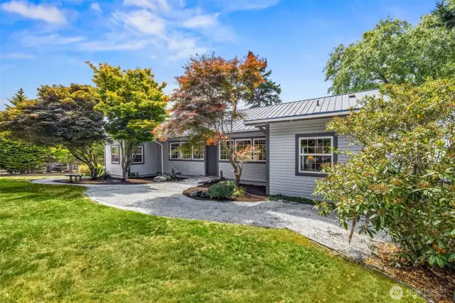 From the west gate, a gently winding pathway leads you through the natural landscape toward the home’s front entrance—setting the tone for the peaceful, private, and historic charm that awaits on this unique Samish Island property.