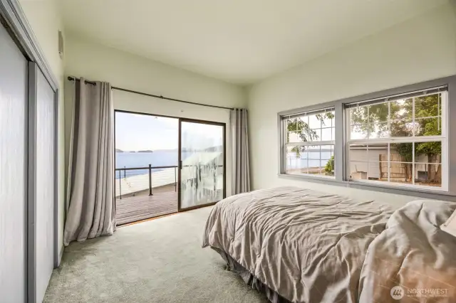 The primary bedroom features a sliding glass door that opens directly onto the deck—offering ever-changing southerly views and a seamless connection to the tranquil waterfront setting.