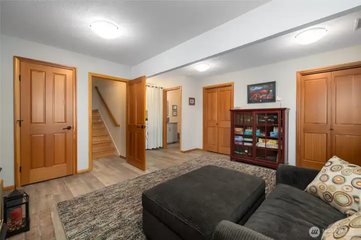 Another view of the family room with wood doors, lots of storage space, garage access and exterior door leading to the wonderful outdoor spaces.