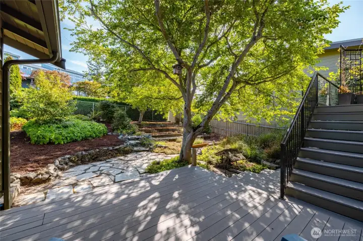 Lovely lower deck nestled in the thoughtfully designed landscaping provides a quiet place for reflection.