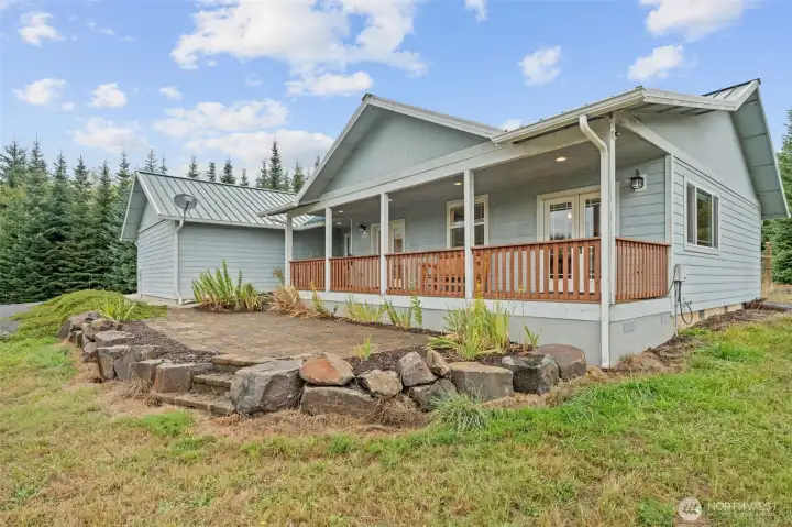 Covered Trex deck and paver patio invite you to relax and take in the front yard and pond views.