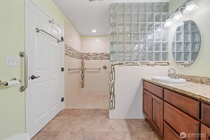 Accessible shower with wall-mounted grips for comfort and safety.