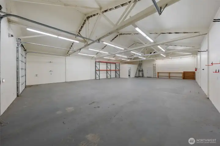 Shop view with corner office, workbench, pegboard, and exterior door.