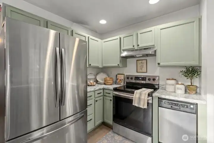 Cozy kitchen with stainless steel appliances. (some decor digitally staged)