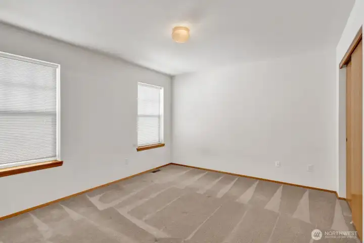 The main floor primary bedroom offers comfort and convenience, complete with a double closet for ample storage and a private attached primary bath. It’s a quiet retreat designed for easy main-level living.