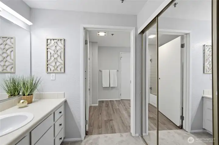 The primary suite features two closets, plus this vanity. The full bath with a second vanity is through the door.