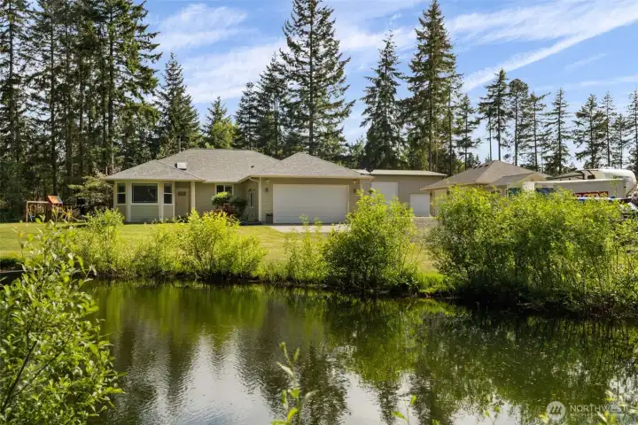 Set behind a tranquil front pond and framed by open sky, this home makes a memorable first impression before you ever step inside.