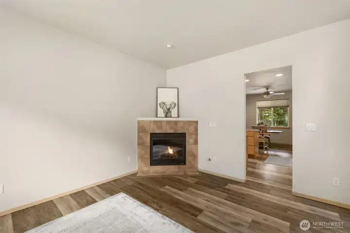 Fresh paint, clean lines, warm wood grain laminate floors, and a corner fireplace give this living room a calm, move in ready feel with room for your own style.