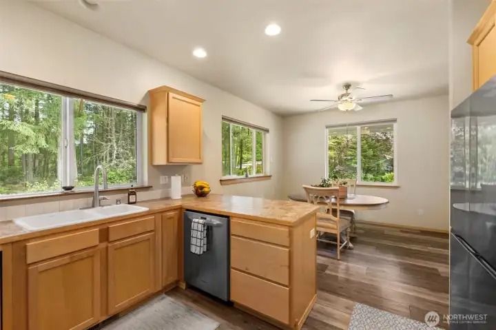 The kitchen and dining area feel connected to the landscape, with wide windows, peaceful tree views, and an easy layout for everyday meals or relaxed gatherings.