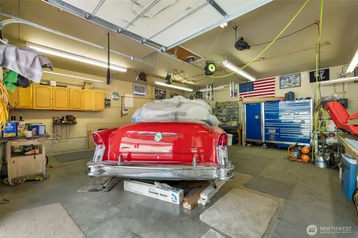 Inside the smaller shop, radiant heated floors with a dedicated water heater system, cabinetry, strong lighting, and open workspace create a comfortable year round setting for projects, vehicles, tools, or serious hobby use.