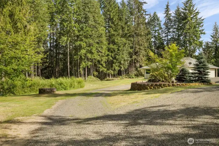 The approach feels peaceful from the moment you arrive, with a landscaped entry, trees framing the home, and a setting that immediately invites you to slow down and stay awhile.