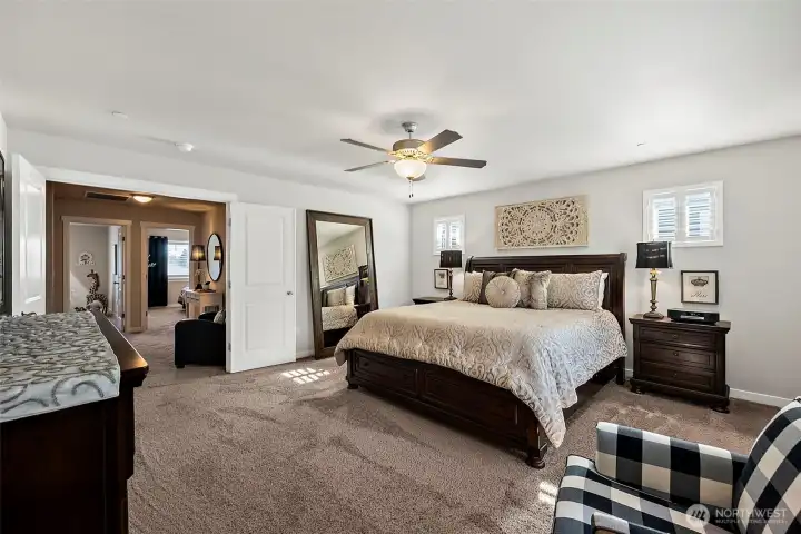The grand primary suite with double door entry offers a decorative ceiling fan light and cushy carpeting The grand primary suite with double door entry offers a decorative ceiling fan light and cushy carpeting
