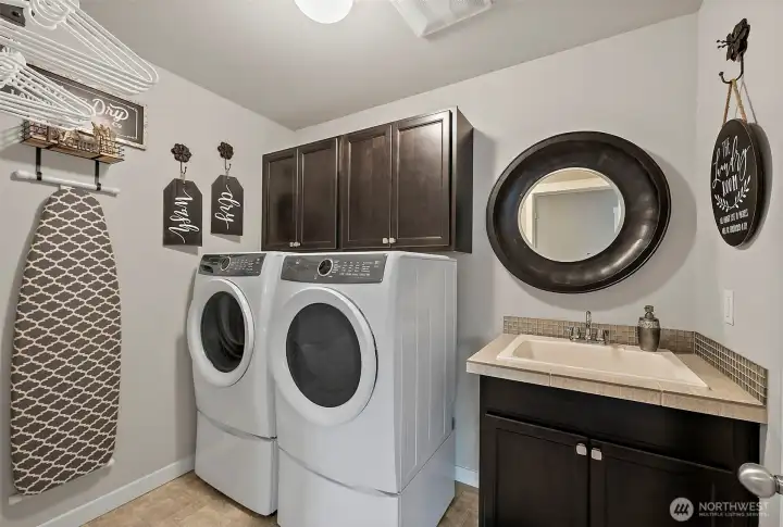 The upper level laundry with utility sink and added storage is a lovely space to do the laundry and the front load washer & dryer with pedestals are included The upper level laundry with utility sink and added storage is a lovely space to do the laundry and the front load washer & dryer with pedestals are included