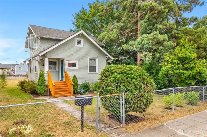 Large fully fenced lot w/ adorable cedar staircase to a covered front porch.