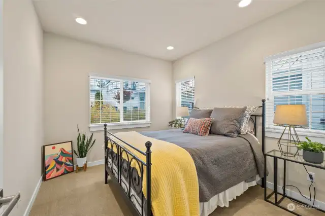 Main level bedroom just off the entrance to the home. Wood faux blinds allow for privacy when needed.