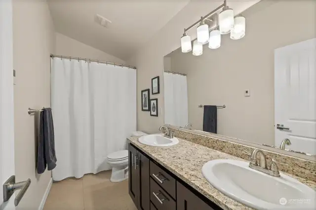 The upper level five-piece bathroom is conveniently placed between bedrooms. The spa like bathroom offers tile floors accompanied by a large vanity with double sinks and plentiful storage space.